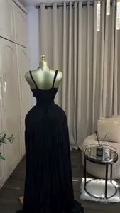 Elegant black pleated high-waist maxi dress shown on a golden mannequin from the back view