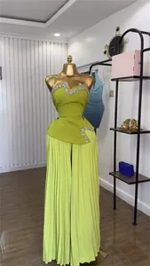 Lindgrünes Set aus trägerlosem Top mit Strass-Details und plissierter weiter Hose.