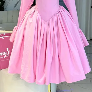 Close-up of elegant pink long sleeve A-line dress showing high waist pleated detail.