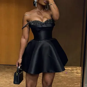 Elegant black mini dress featuring a sequin patchwork bust and a flared satin skirt.