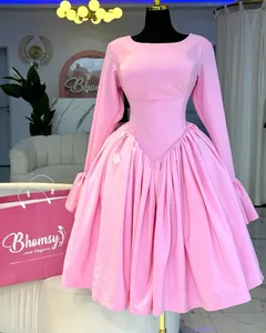 Detailed view of an elegant pink long-sleeved A-line dress on a mannequin.