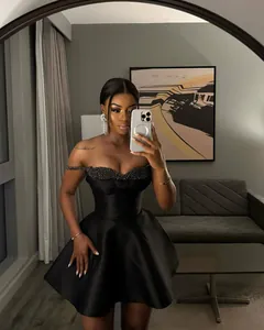 Elegant black off-shoulder mini dress featuring sequin patchwork and premium satin finish