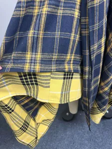 Close-up view showing the fabric texture and plaid pattern of an asymmetrical skirt