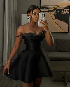 Elegant black off-the-shoulder mini dress featuring shimmering sequin bodice detail for party