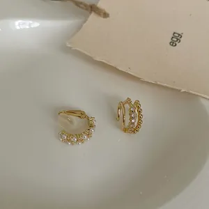 Macro view of gold-tone multi-layer pearl and rhinestone non-pierced ear cuff jewelry
