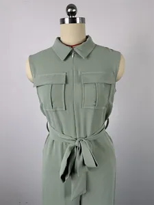 Detail view of a sleeveless sage green jumpsuit featuring lapel collar and waist tie