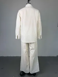 Vista posterior de un conjunto de camisa crema de manga larga y pantalón de talle alto