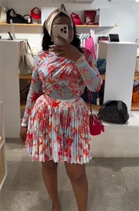 Detalle del elegante conjunto de top de manga larga y minifalda plisada con estampado de coral