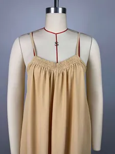 Primer plano del vestido beige de tirantes con escote plisado y textura de tela