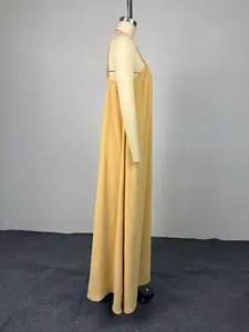 Vista lateral de un elegante vestido largo amarillo jengibre en un maniquí de pie