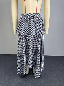 Detail view of high waist gingham midi skirt featuring irregular layered ruffle hem and tie