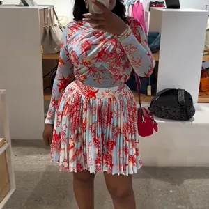 Ajuste real de un conjunto de top cruzado y falda plisada con estampado de coral