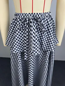 Detailed view of black and white gingham high-waisted skirt with lace-up bow and tiered hem