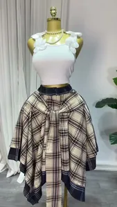 Detail view of a high-waisted plaid A-line skirt with an irregular bow-tie design