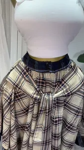Detail view of a high-waist plaid A-line skirt featuring a stylish adjustable tie-waist