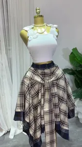 Detail of plaid A-line skirt with irregular hem and tie-waist design on a mannequin.
