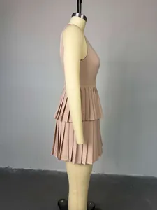 Vista lateral de un vestido plisado corto sin mangas en color nude sobre un maniquí