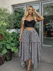 Stylish black and white plaid A-line skirt with high waist and irregular hem.