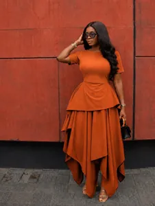 Detail of orange irregular hem dress showing layered ruffles and elegant drape