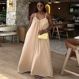 Detalle de cuerpo entero de un vestido largo beige de tirantes finos en una modelo en un café.