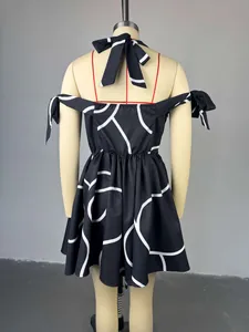 Back view of a black and white geometric print halter neck dress with bow details.