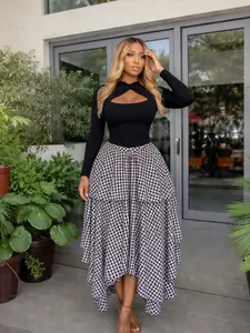 Detail view of high-waisted asymmetrical gingham midi skirt with layered tiered hem.
