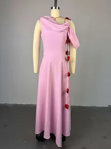 Detail view of a pink midi dress with elegant shoulder draping and red flower accents.