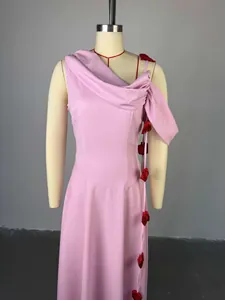 Detail showing a pink off-shoulder midi dress with delicate decorative red rose elements.