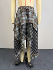 Macro view showing the double-layered asymmetrical plaid skirt design on mannequin