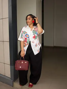 Donna alla moda con camicia bianca a maniche corte con vivace stampa floreale e colletto
