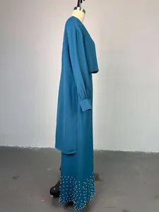 Side view of teal blue irregular lantern sleeve top and pearl beaded wide leg pants set