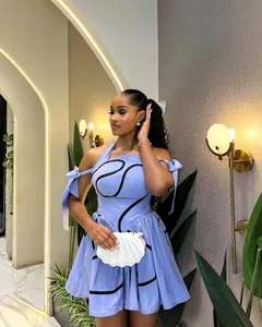 Detail of a light blue halter dress with black wave patterns and shoulder bows.