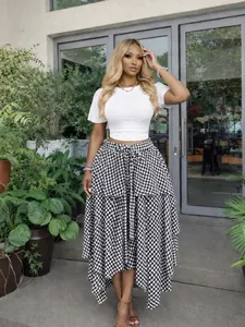 Outdoor lifestyle shot of a woman in a black and white checkered irregular hem skirt