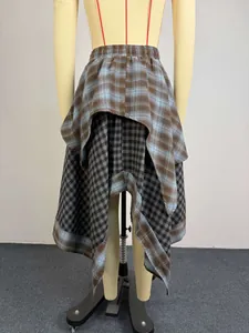 Detailed back view of an asymmetrical layered plaid skirt with mixed brown and grey patterns
