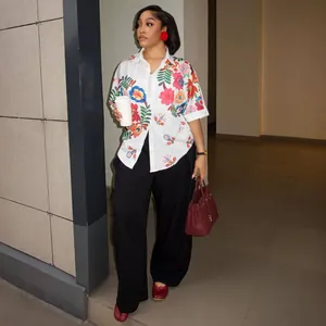Elegante camicia bianca da donna a maniche corte con stampe floreali colorate e colletto