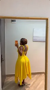Vista dettagliata di un set giallo a due pezzi con spalline a pompon e lacci sul retro
