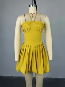 Detailed view of yellow halter neck mini dress with high waist and pleated skirt