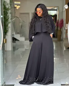 Detail view of stylish black two-piece set with lantern sleeves and pearl beaded hem