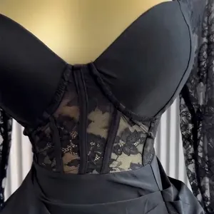 Close-up detail of an elegant black corset dress with intricate floral lace at the waist.
