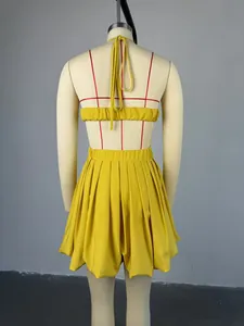 Rear view of yellow halter bandeau top and pleated high waist mini skirt on mannequin.