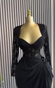 Elegant black lace long-sleeve dress featuring a corset waist and draped skirt