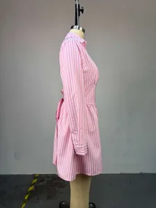 Vue latérale d'une robe rose et blanche à rayures avec manches longues et laçage.