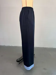 Side view of navy high-waisted trousers with blue striped patchwork hem.