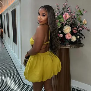 Back view of a chic yellow halter backless mini dress with a pleated skirt detail.