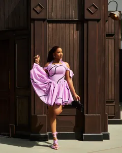 Elegant purple halter-neck pleated dress with black wave patterns and off-shoulder straps.