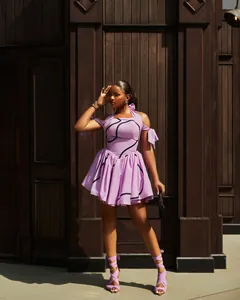 Full-body shot showing the fit and flow of the purple halter neck pleated dress