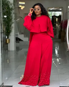 Red two-piece set featuring a lantern sleeve top and pearl-embellished wide-leg pants.