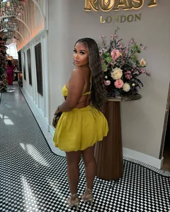 Back view of a chic yellow halter backless mini dress with a high-waisted puffy skirt