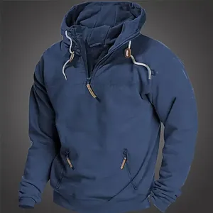 Detail eines blauen Herren-Kapuzenpullovers mit Viertelreißverschluss und Taschen.