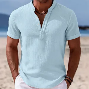 Detail view of men's light blue short sleeve linen shirt with stand collar on beach